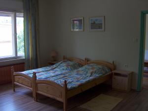 - une chambre avec un lit en bois et une fenêtre dans l'établissement Apartmanház Sipos Siófok, à Siófok