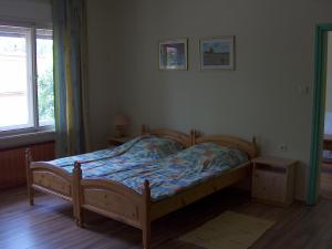 a bedroom with a wooden bed and a window at Apartmanház Sipos Siófok in Siófok