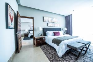a bedroom with a king sized bed and a chair at Square Small Luxury Hotel - Nuevo Consulado in Guadalajara