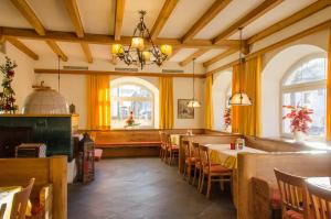 a restaurant with tables and chairs and windows at Gasthof Goldener Fisch in Lienz