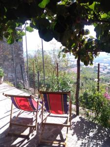 two chairs sitting on a porch with a view at House with stunning views in Chiusdino