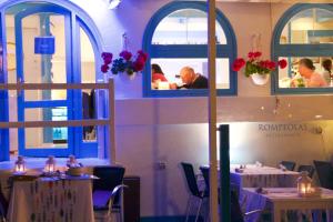 a restaurant with tables and chairs and people in the mirror at AVANTI Lifestyle Hotel - Only Adults in Corralejo