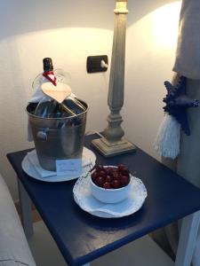 a table with a bottle of wine and a bowl of cherries at Relais Fenicottero Rosa in Porto San Paolo