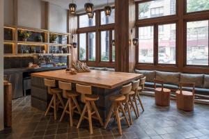 una cucina con un grande tavolo di legno e sgabelli di MADE Hotel a New York