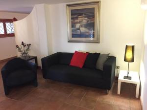un soggiorno con divano nero e sedia di Le Due Pigne a Taranto