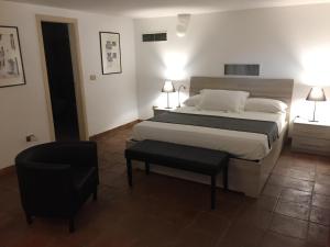 a bedroom with a bed and a chair in it at Le Due Pigne in Taranto