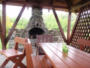 a wooden table and chairs in front of a stone fireplace at Penzion Harvanek in Vlachovice