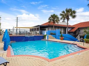 a swimming pool with a water slide in front of a house at Beachside Inn in Destin