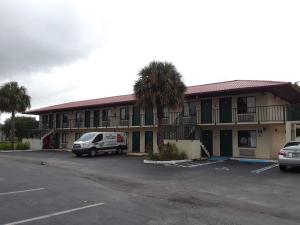 a hotel with a van parked in a parking lot at Riviera Motel in Kissimmee