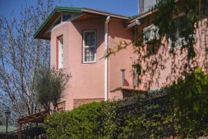 una casa rosa con una ventana en el lateral. en Piscoyaku Apart en Potrero de los Funes