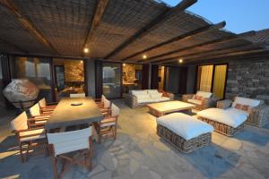 eine Terrasse mit einem Tisch, Stühlen und einem Sofa in der Unterkunft Villa Molivos Views in Mythimna