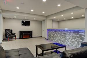a living room with a couch and a fireplace at Knights Inn Kamloops in Kamloops