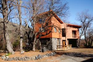 una grande casa nel bosco con alberi di Cabañas Las Cabras a Las Trancas