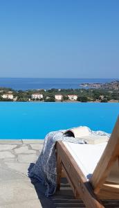 ein Bett auf einem Deck neben einem blauen Pool in der Unterkunft Villa Molivos Views in Mythimna