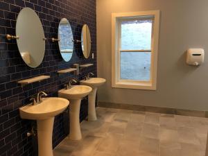 a bathroom with two sinks and mirrors and a window at Apple Hostels of Philadelphia in Philadelphia
