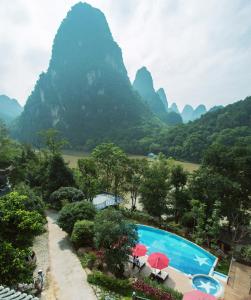a view of a swimming pool with mountains in the background at Li River Resort in Yangshuo