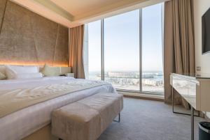 ein Schlafzimmer mit einem großen Bett und großen Fenstern in der Unterkunft The Grove Hotel & Conference Centre Bahrain in Manama