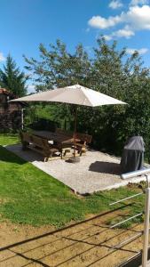 Gite des 3 bouleaux في Robelmont: مظلة بيضاء ومقعد وطاولة