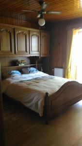 Gite des 3 bouleaux في Robelmont: غرفة نوم بسرير كبير مع مروحة سقف