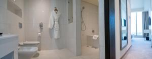 a bathroom with a toilet a sink and a shower at The Grove Hotel & Conference Centre Bahrain in Manama