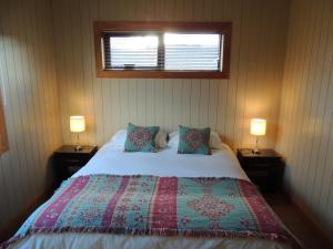 a bedroom with a large bed with two lamps at La Cascada Duplex in San Martín de los Andes
