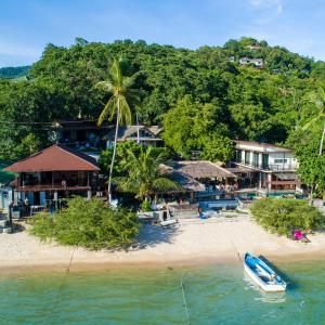 a boat on a beach next to a resort at New Heaven Dive School and Resort in Koh Tao