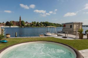 马尔肖Inselhotel Ringelnatz的水体旁草丛中的热水浴池