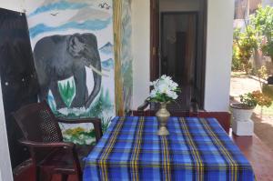 a dining room with a table and a painting of an elephant at Bentota Orchid House in Bentota