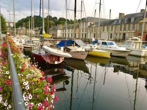 a group of boats docked in a harbor with flowers at Hôtel Fontaine Morlaix in Morlaix