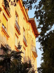 a yellow building with balconies on the side of it at App Obrovac in the centre - with amazing sea view! in Pula