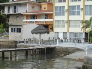 a dock with an umbrella and a building at Hotel Veleiro in Florianópolis