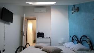 a bedroom with two beds and a television in it at Dormi da me sul mare in Civitanova Marche