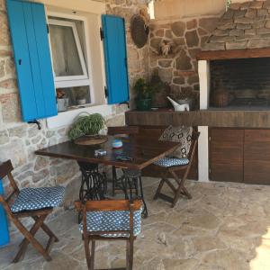 a kitchen with blue cabinets and a wooden table and chairs at Dream house in Zaglav