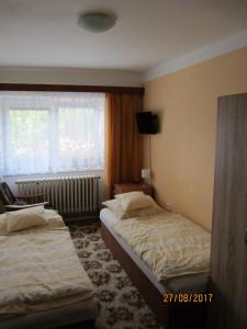 2 łóżka w pokoju hotelowym z oknem w obiekcie Ubytovani U babicky w mieście Velké Losiny