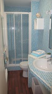 un bagno piastrellato blu con un water e un lavandino di Studio Front Mer a Le Touquet-Paris-Plage