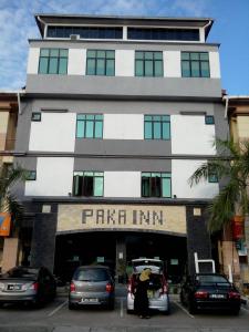 a woman is standing in front of a building at Hotel Paka INN in Paka