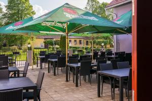 eine Gruppe von Tischen und Stühlen mit Sonnenschirmen in der Unterkunft Hotel Hubert in Slavonice