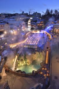 a night view of a city with a hot tub at Hotel Takamatsu in Kusatsu