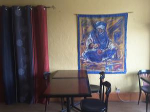 a table and chairs in a room with a painting at Le Logis du Pré Braheux in Saint-Nabord