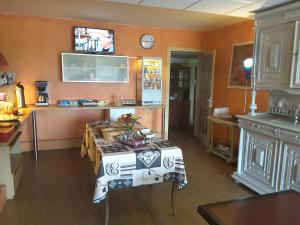 - une cuisine avec une table au milieu d'une pièce dans l'établissement Le Logis du Pré Braheux, à Saint-Nabord