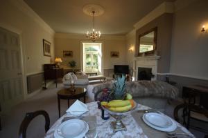 a living room with a table with a bowl of fruit on it at The Dower House Apartments in Lincoln