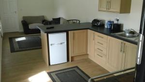 eine Küche mit einem weißen Kühlschrank und einer Spüle in der Unterkunft Keepers Cottage in Forsinain