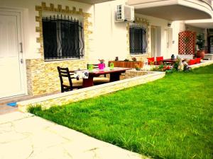 a backyard with a table and chairs in the grass at Iro Apartment in Nea Peramos