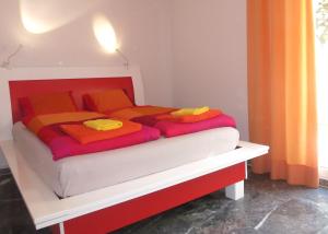 a bed with colorful blankets and pillows on it at Flower Garden in Mati