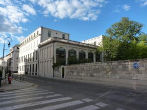 an empty street with a building on the side of the road at Appart charme Arenes Nimes in Nîmes