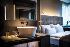 a hotel room with a sink and a bed at SAKS Urban Design Hotel Frankfurt in Frankfurt