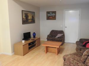 a living room with a couch and a tv and a table at The Shack in Dartmouth