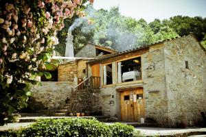 a stone house with smoke coming out of it at Fervenza Casa Grande & Restaurante in Reguengo
