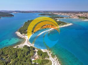 a yellow parachute is flying over a island in the water at Apartments 770 in Medulin