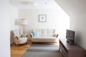 a living room with a couch and a tv at Toila Valgevilla Apartments in Toila